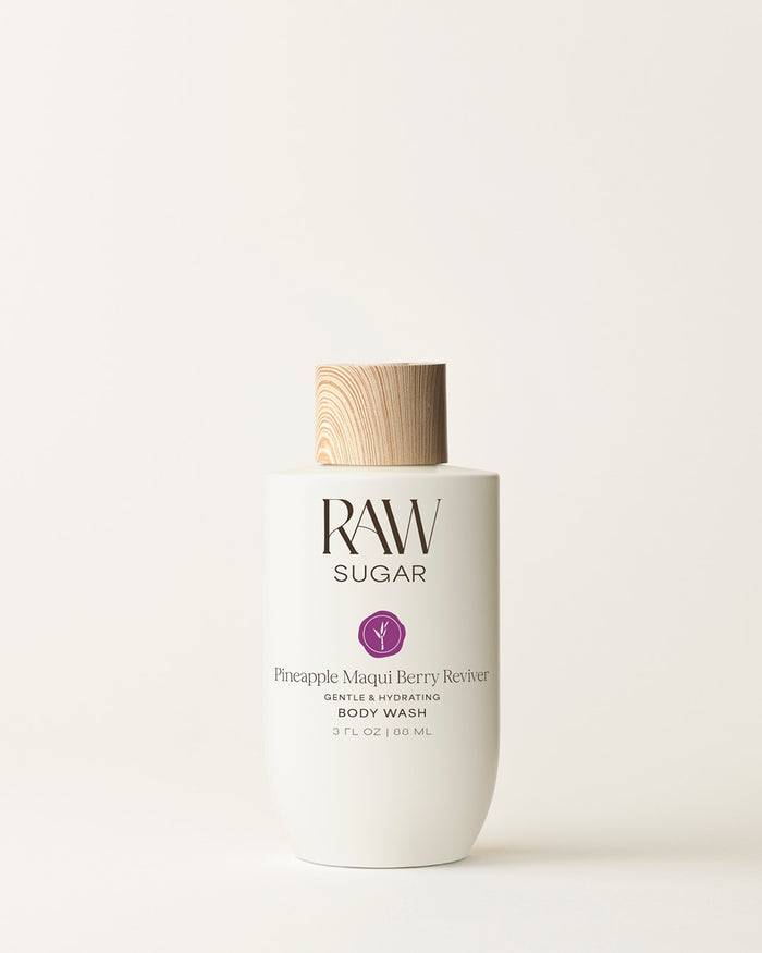 Bottle of Travel Raw Sugar Pineapple Body Wash on a cream background, designed to help gently cleanse and hydrate skin with clean ingredients.