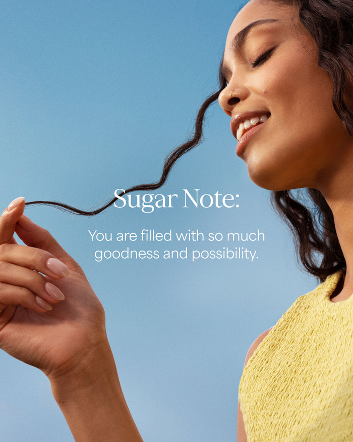 Woman holding a strand of hair with a motivational quote on a blue background
